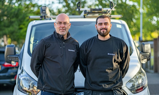 two colleagues standing in front of a Bromford van