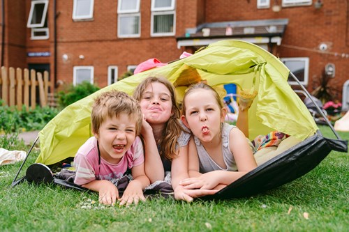 Three children play in the garden of a Bromford home