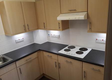 Kitchen of flat displaying gas hob, worktop space and 10 cupboards.