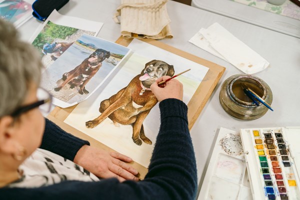Woman painting a picture of a dog