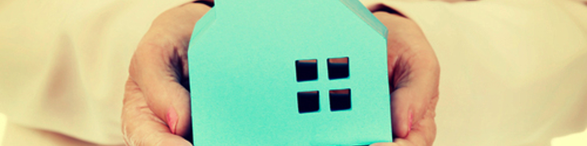 Small blue house being held in a persons hands
