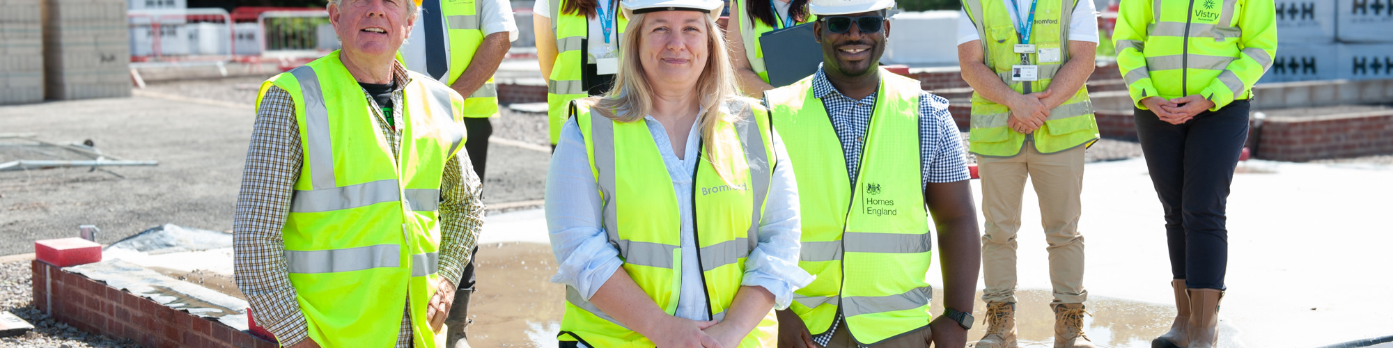 Colleagues on a construction site wearing hard hats and hi vis vests
