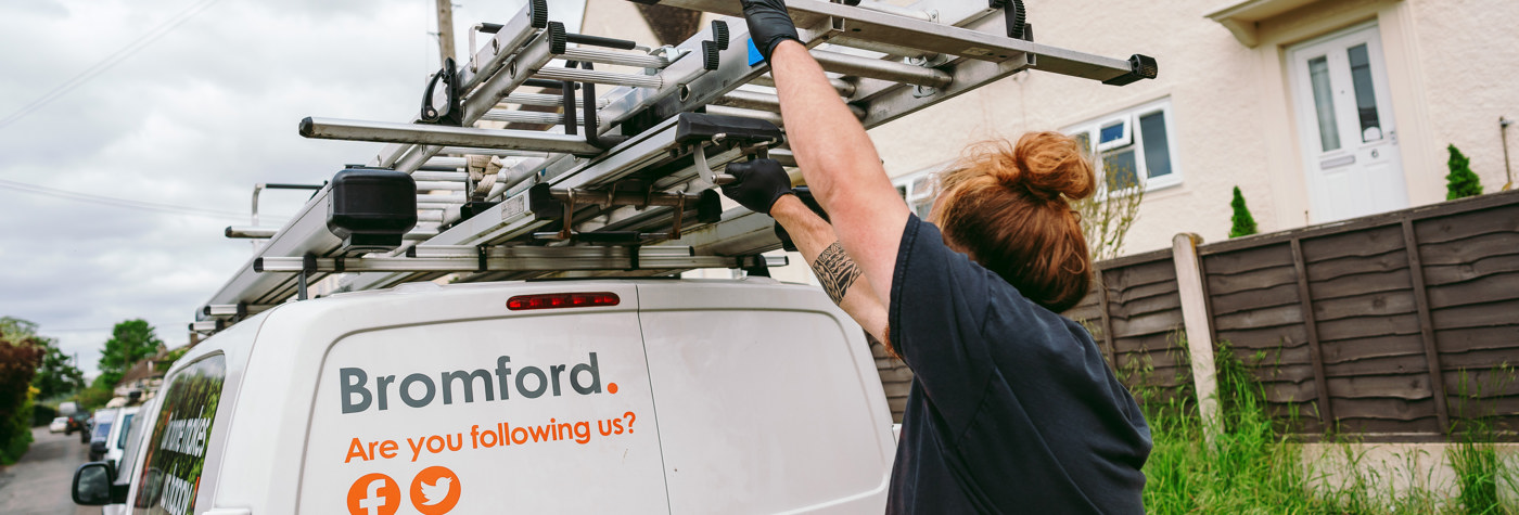 A Bromford colleague taking a ladder from a Bromford van 