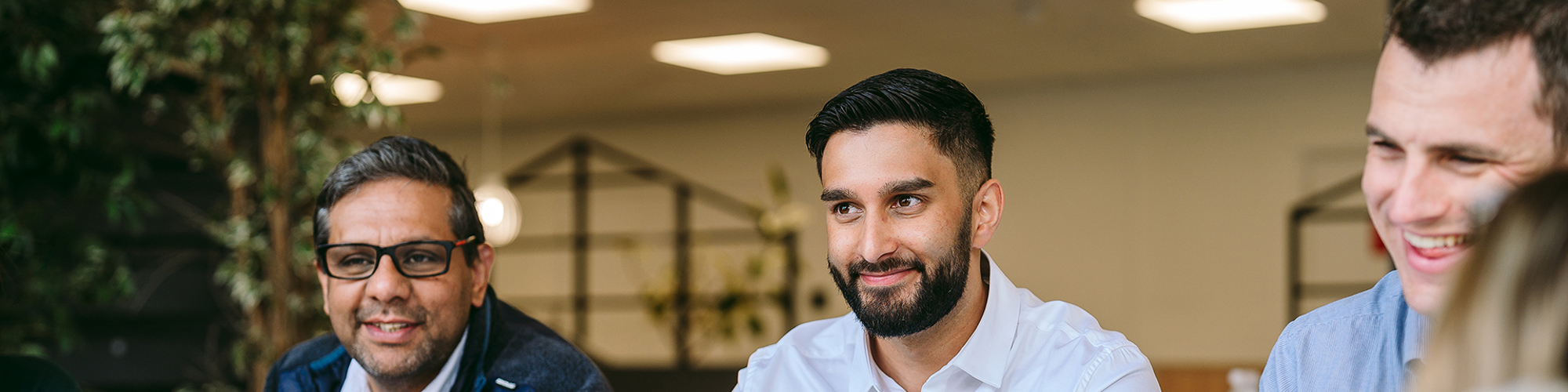 3 bromford colleagues sitting side by side and smiling