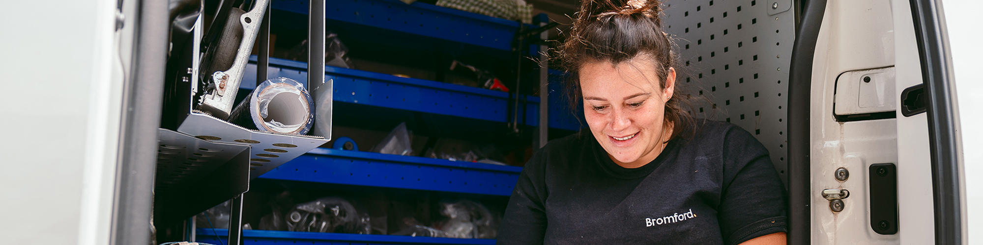 a bromford colleague sitting in a van using a tablet