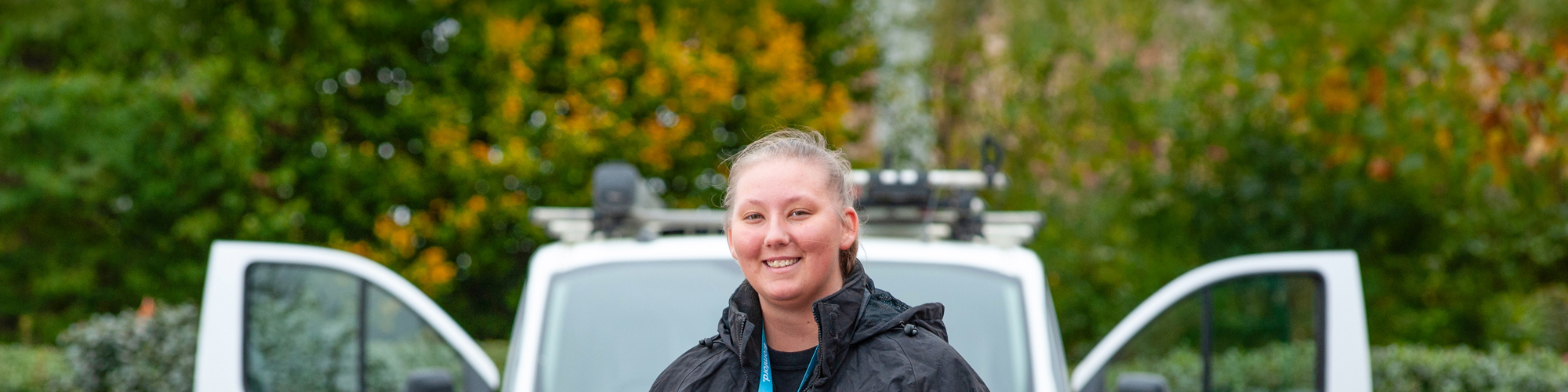 Ebony Hawker holding tools in front of her van