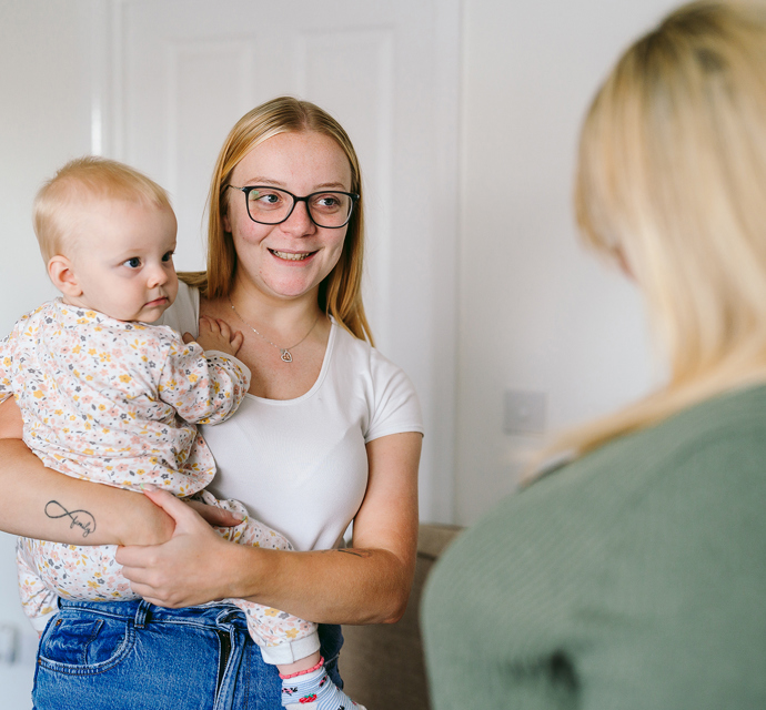 a mother and child talking to their neighbourhood coach