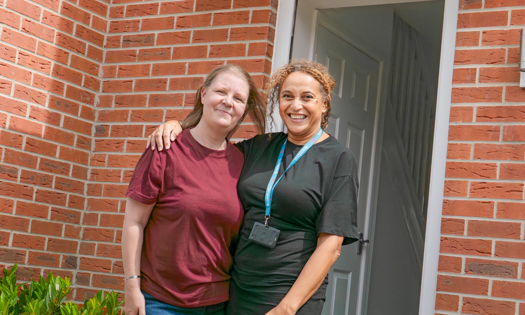 Two people standing in front of a home
