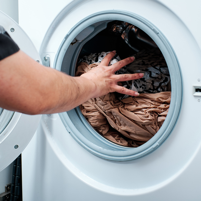 Close Up Of Hands Putting Clothes Into Washing Mac 2025 03 08 08 39 18 Utc
