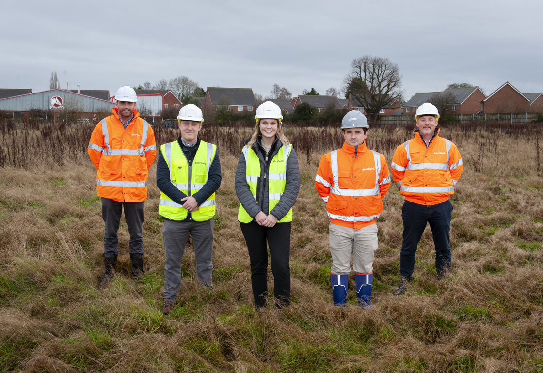 Five people smiling and each wearing a high-vis