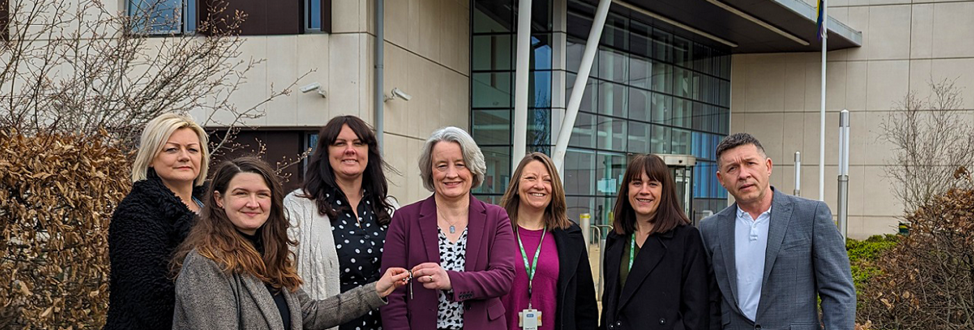 Colleagues standing and holding keys 