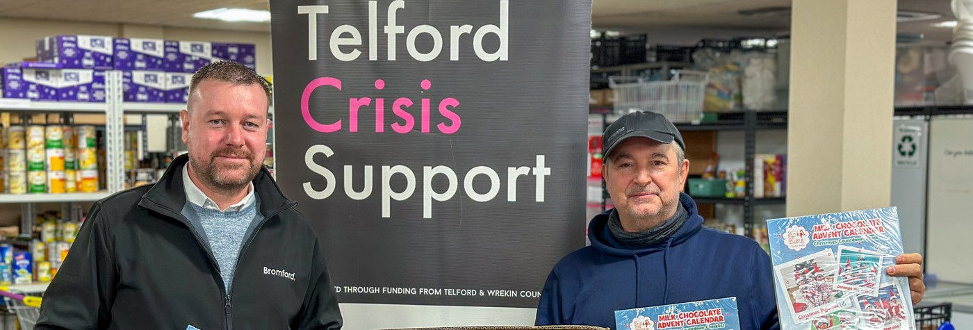 Two people holding advent calendars at Telford foodbank  