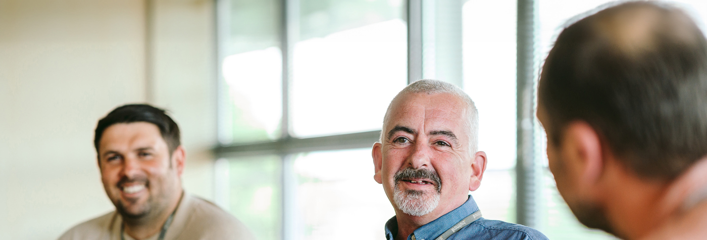 Bromford colleagues sitting  talking in a meeting room